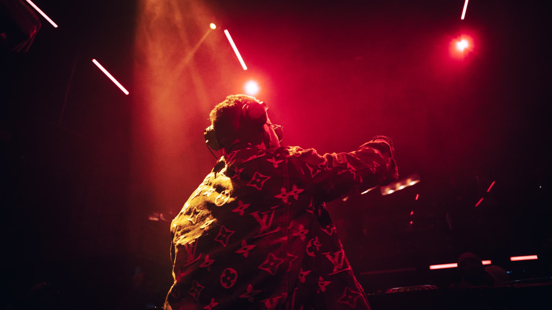 FARZY silhouetted in red haze and laser beams